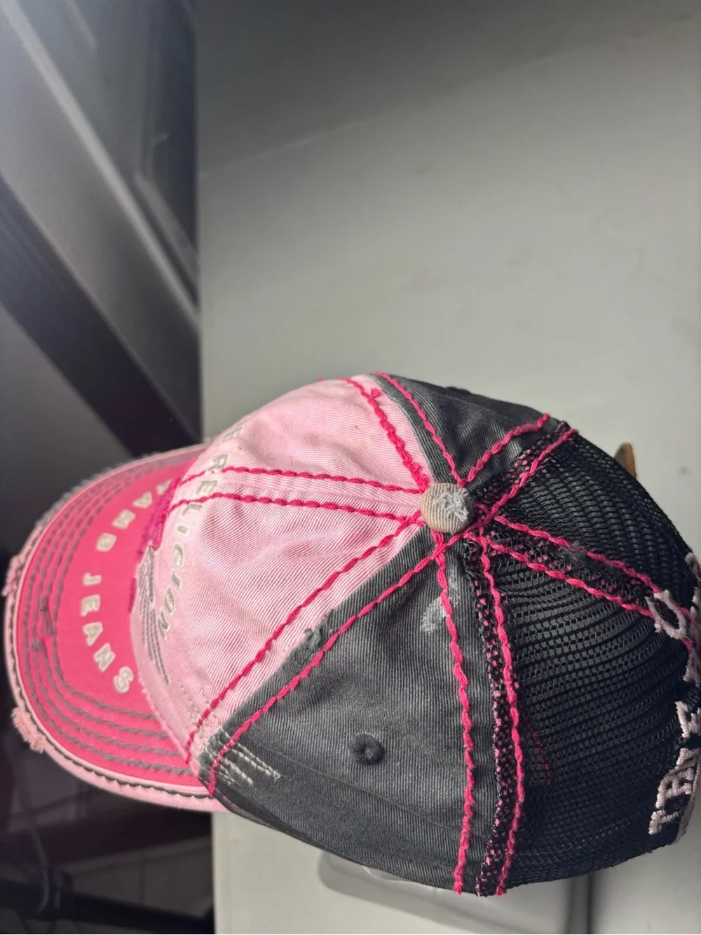 pink, distressed True Religion brand jeans cap with embroidered wings and a logo
